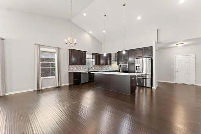 a view of kitchen with cabinets counter top space stainless steel appliances and wooden floor