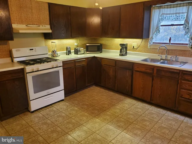 a kitchen with a sink a stove and cabinets