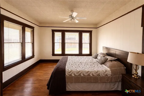 a bedroom with a large bed and a large window with outer view
