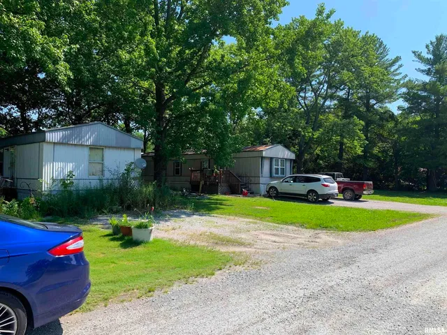 a view of a house with a yard and a large tree