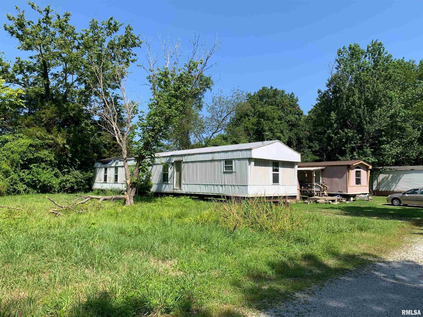 5281-5287 Country Club Road, Unit 1 2 Murphysboro, IL 62966 - Photo 29 of 50 a house that is sitting in the grass with large trees and plants