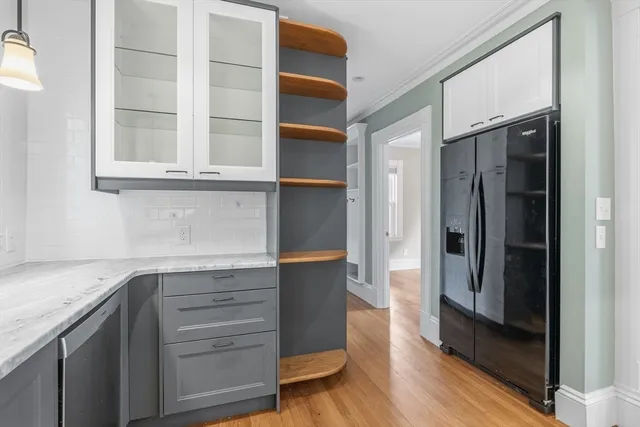 a kitchen with a wooden floor and cabinets