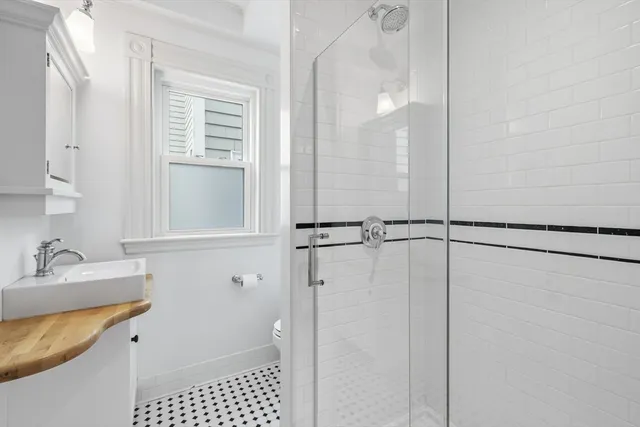 a bathroom with a sink a toilet and shower