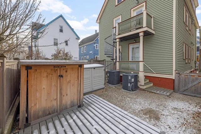 a view of a house with a barbeque and wooden stairs