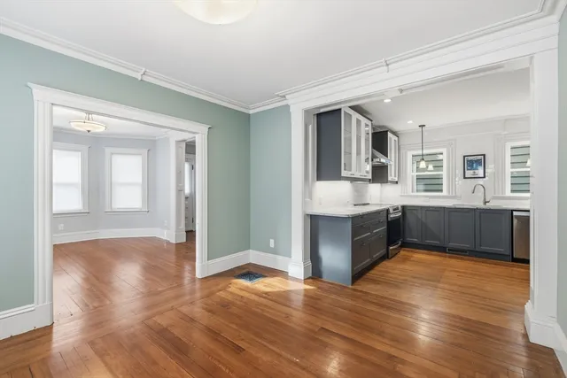 a large kitchen with stainless steel appliances granite countertop a large counter top and a wooden floor