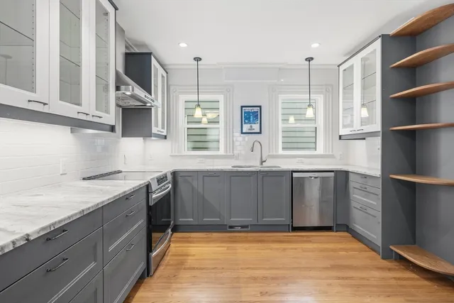 a kitchen with stainless steel appliances granite countertop a sink window and cabinets