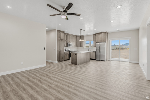 169 West 100 South Joseph, UT 84739 - Photo 35 of 35 Kitchen with light countertops, open floor plan, a center island, stainless steel appliances, and a textured ceiling