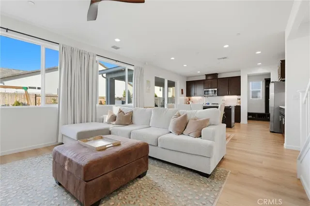 a kitchen with stainless steel appliances kitchen island granite countertop a refrigerator a stove a sink a dining table and chairs