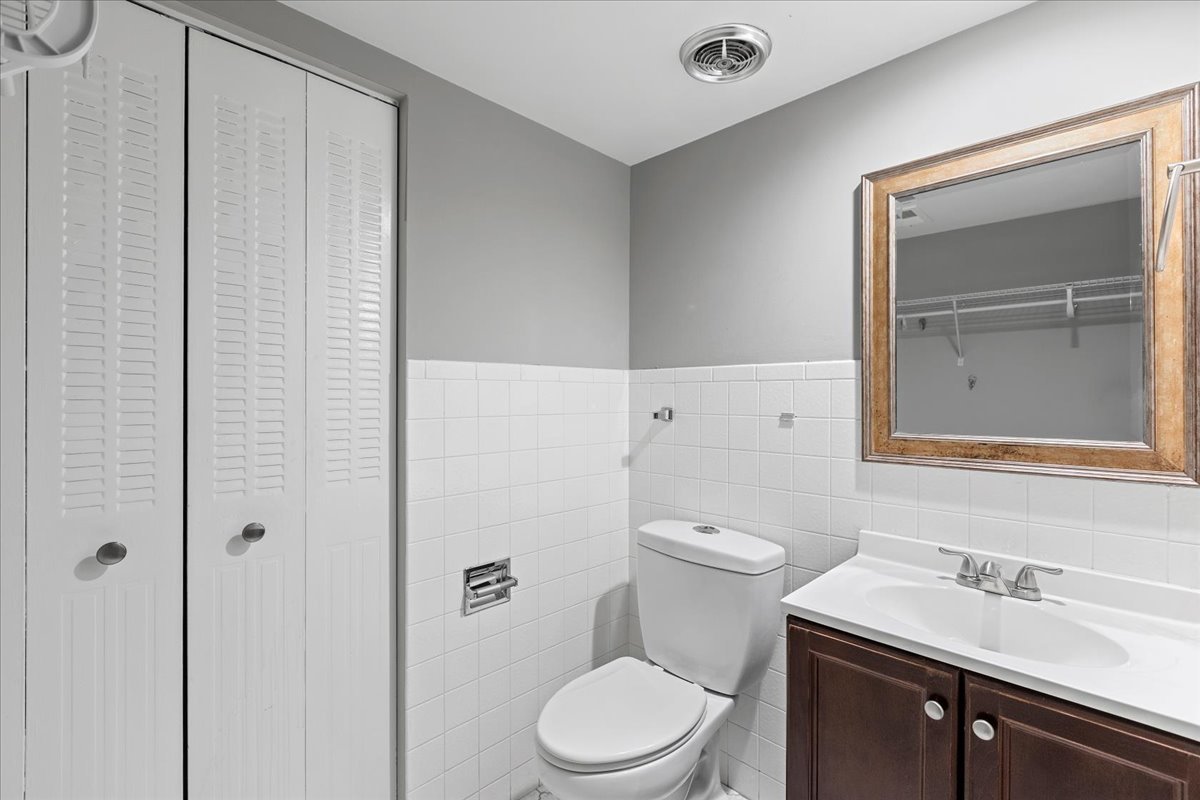 8000 Woodglen Lane, Unit 109 Downers Grove, IL 60516 - Photo 11 of 18 a bathroom with a granite countertop sink vanity mirror and toilet
