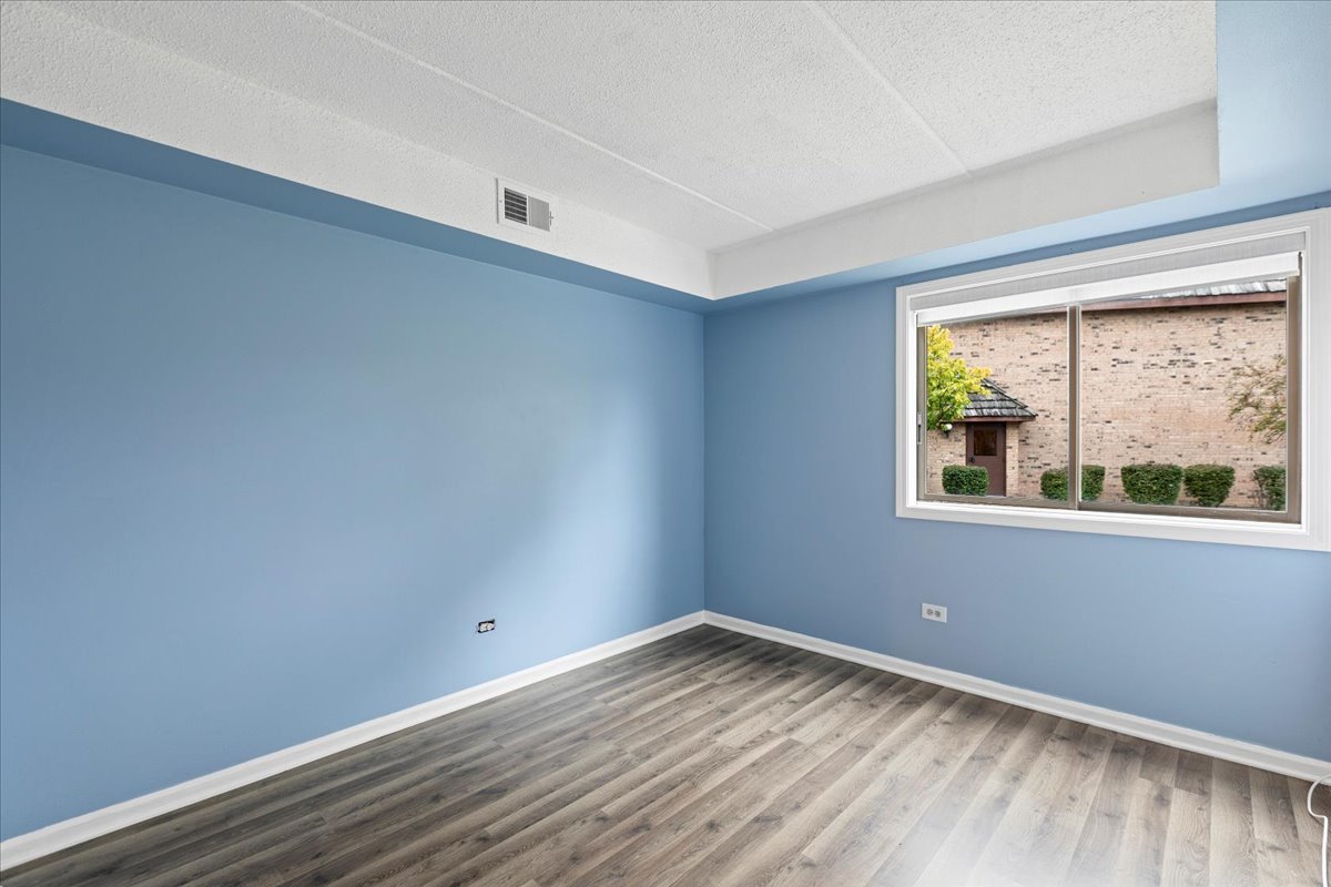 8000 Woodglen Lane, Unit 109 Downers Grove, IL 60516 - Photo 13 of 18 a view of empty room with wooden floor and fan