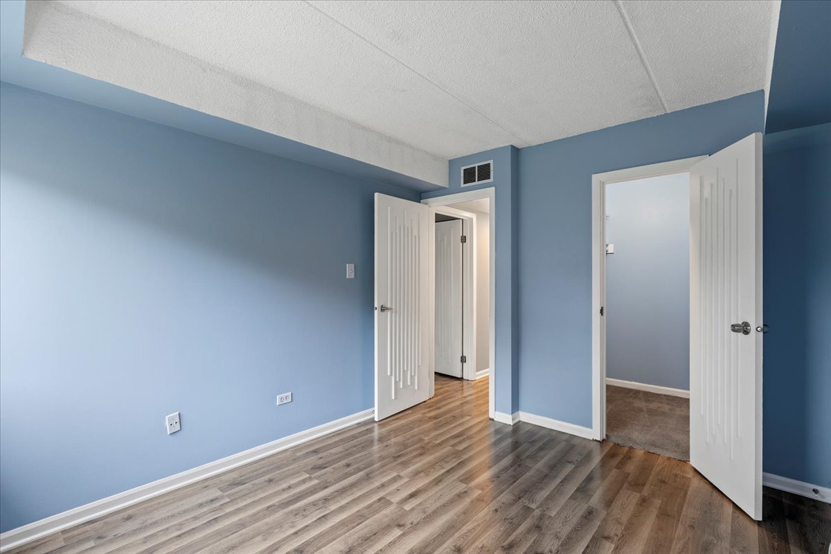 8000 Woodglen Lane, Unit 109 Downers Grove, IL 60516 - Photo 14 of 18 a view of an empty room with wooden floor and closet
