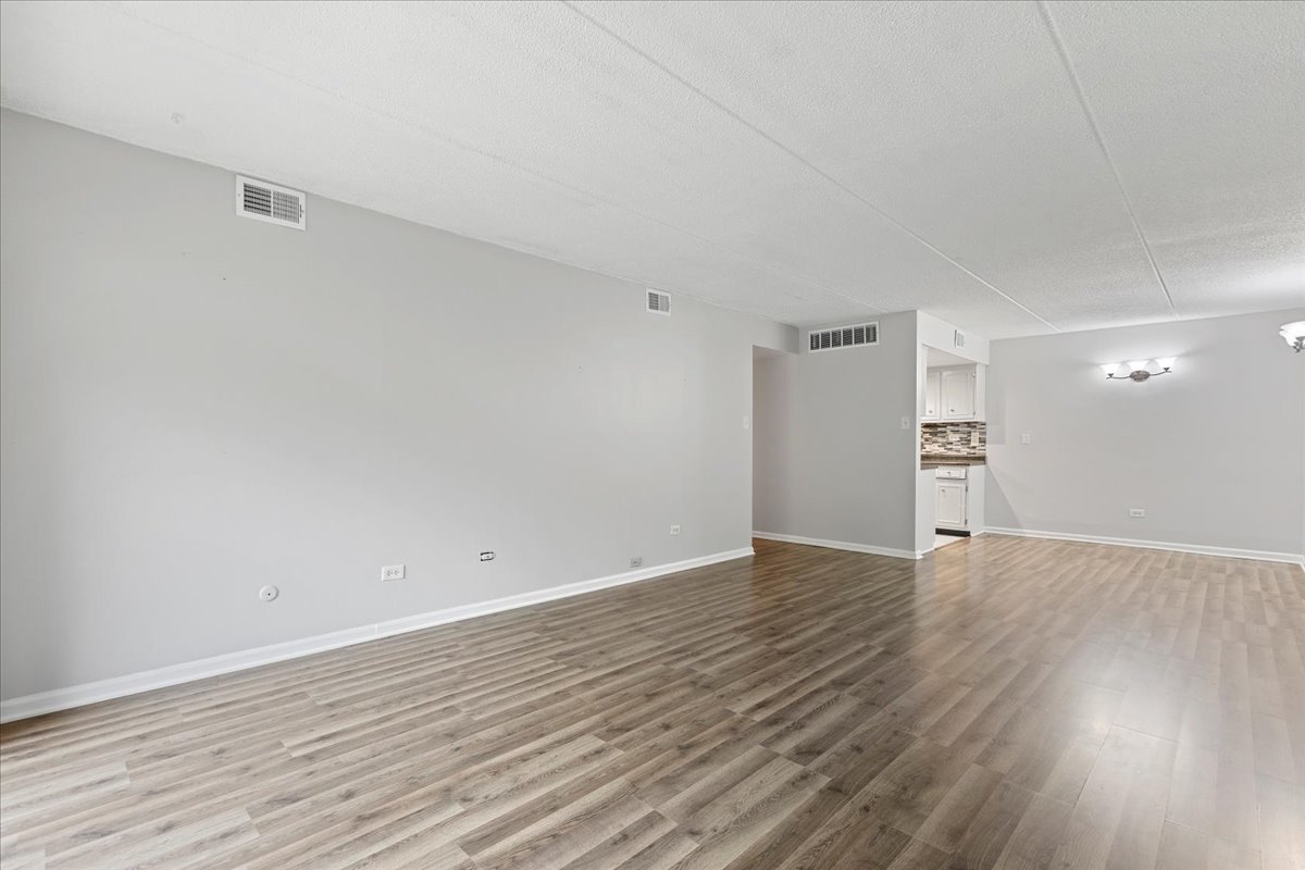 8000 Woodglen Lane, Unit 109 Downers Grove, IL 60516 - Photo 5 of 18 a view of an empty room with wooden floor and a window