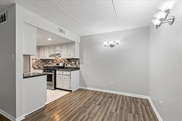 a kitchen with a refrigerator and white cabinets