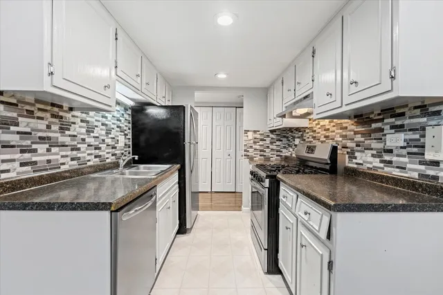 a kitchen with stainless steel appliances granite countertop a sink stove and refrigerator