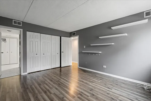 a view of an empty room with wooden floor