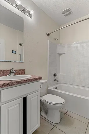 a bathroom with a granite countertop toilet a sink and a bathtub