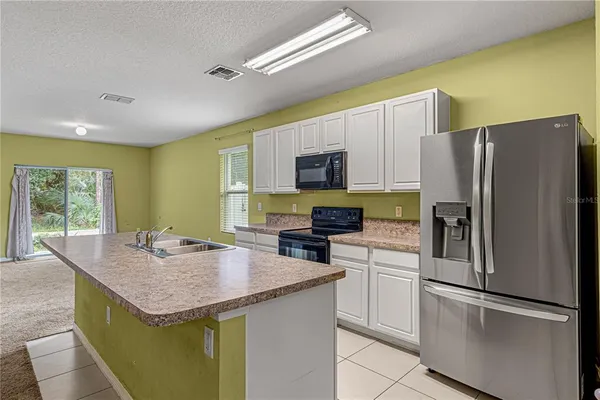 a kitchen with a refrigerator a stove a sink dishwasher and microwave