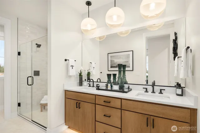 a bathroom with a double vanity sink mirror and shower