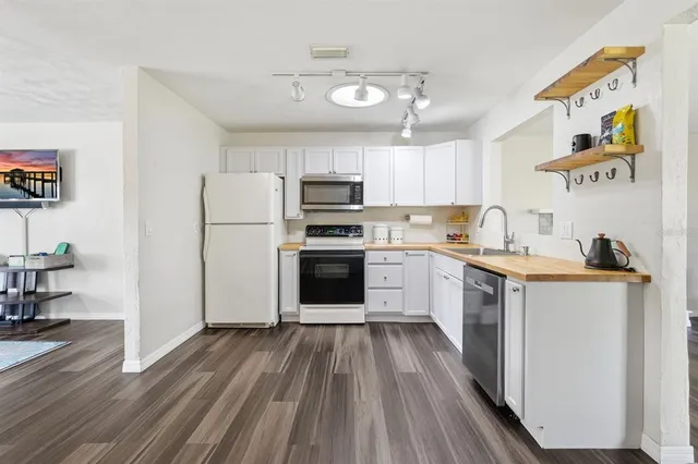 a large kitchen with a lot of counter space and wooden floor