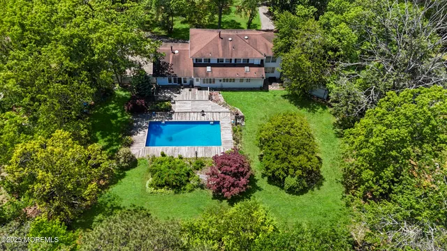 an aerial view of a house with a yard and large trees
