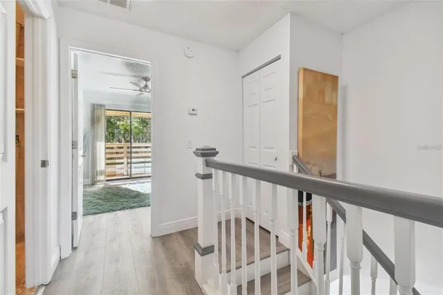 a view of a hallway with wooden floor and entryway