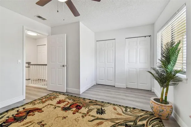 a view of a bedroom with wooden floor and a potted plant