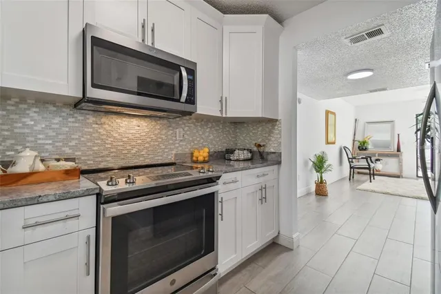 a kitchen with stainless steel appliances a stove microwave and cabinets