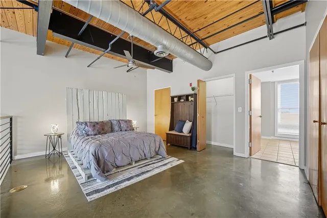 a spacious bedroom with a bed and a chandelier