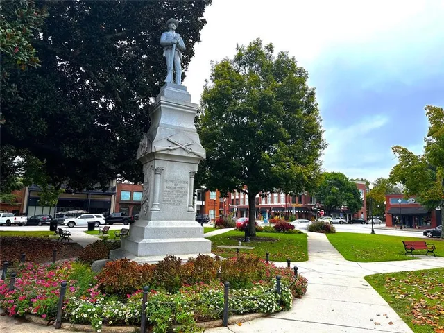 a front view of a house with a yard and trees