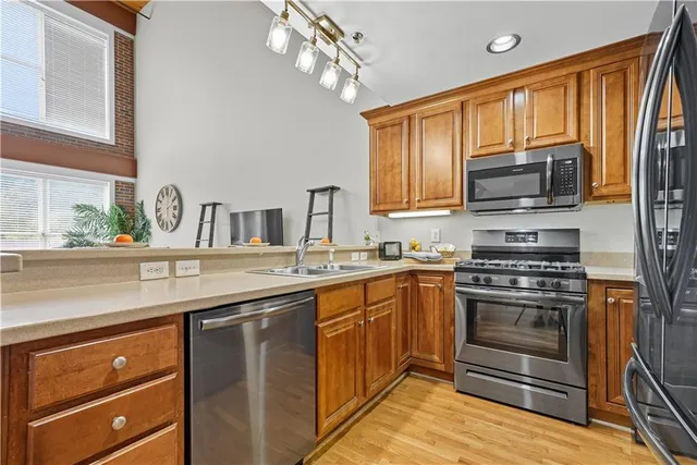 a kitchen with stainless steel appliances granite countertop a sink and stove top oven