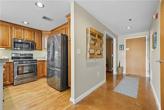 a kitchen with stainless steel appliances granite countertop a refrigerator and a stove
