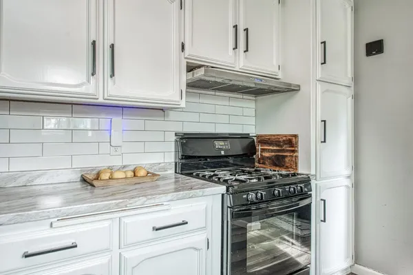 a kitchen with kitchen island granite countertop a sink a counter space appliances and cabinets