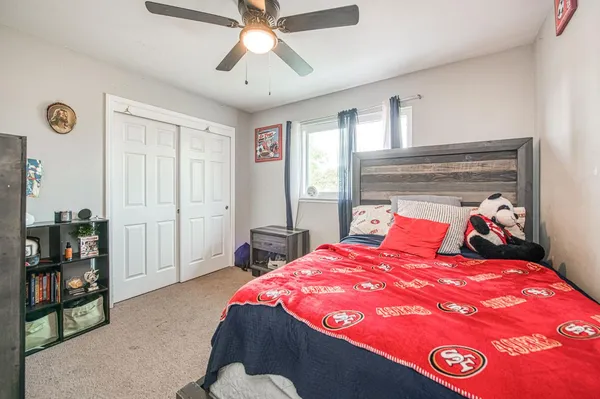 a bedroom with two beds and ceiling fan