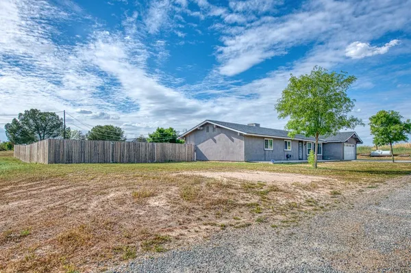 a view of a house with a big yard and large tree