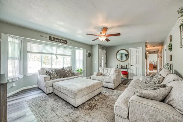 a view of a dining room with furniture a rug and wooden floor