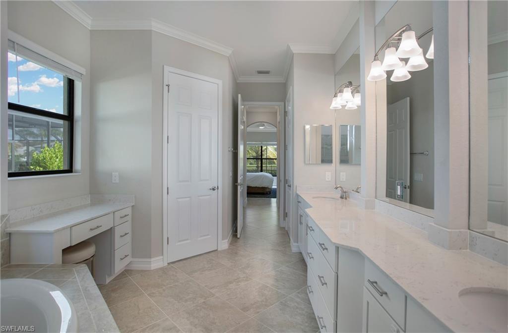 2247 Somerset Place Naples, FL 34120 - Photo 15 of 35 a spacious en suite bathroom with a granite countertop sink a toilet and a mirror