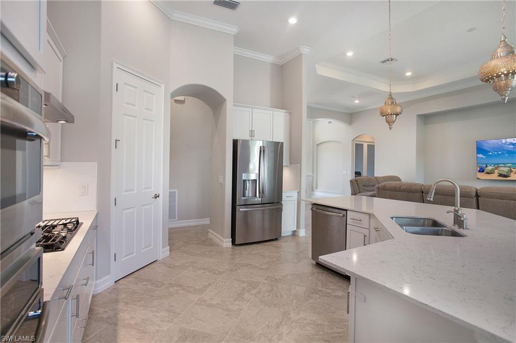 2247 Somerset Place Naples, FL 34120 - Photo 9 of 35 a kitchen with a refrigerator sink and stove
