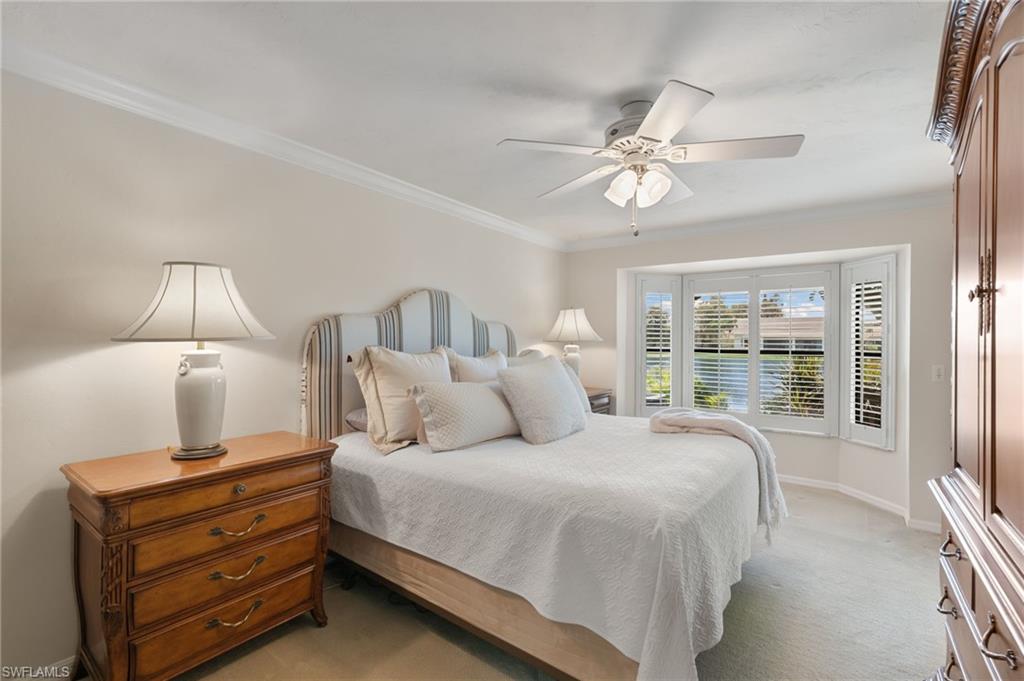 3346 Erick Lake Drive, Unit 2001 Naples, FL 34109 - Photo 13 of 43 a bedroom with a bed chandelier and a large window