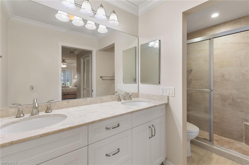 3346 Erick Lake Drive, Unit 2001 Naples, FL 34109 - Photo 18 of 43 a bathroom with a granite countertop sink a toilet and a mirror