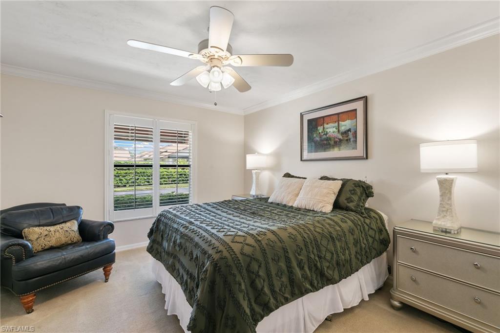 3346 Erick Lake Drive, Unit 2001 Naples, FL 34109 - Photo 20 of 43 a bedroom with a bed and a chandelier