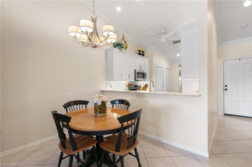 3346 Erick Lake Drive, Unit 2001 Naples, FL 34109 - Photo 8 of 43 a view of a dining room with furniture and chandelier