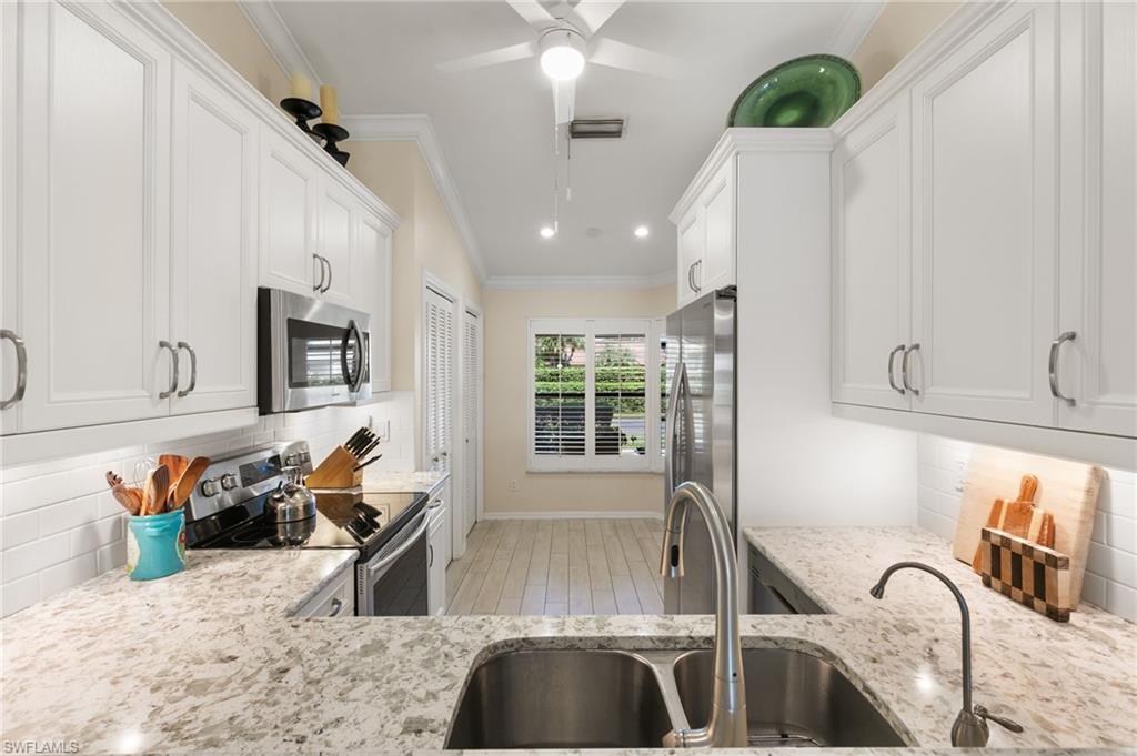 3346 Erick Lake Drive, Unit 2001 Naples, FL 34109 - Photo 9 of 43 a kitchen with stainless steel appliances granite countertop a sink stove and cabinets