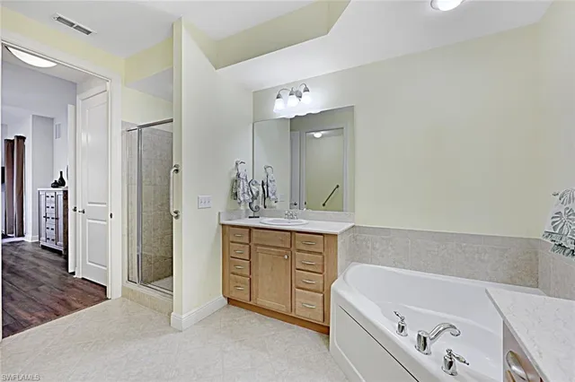 a bathroom with a tub a sink and a mirror