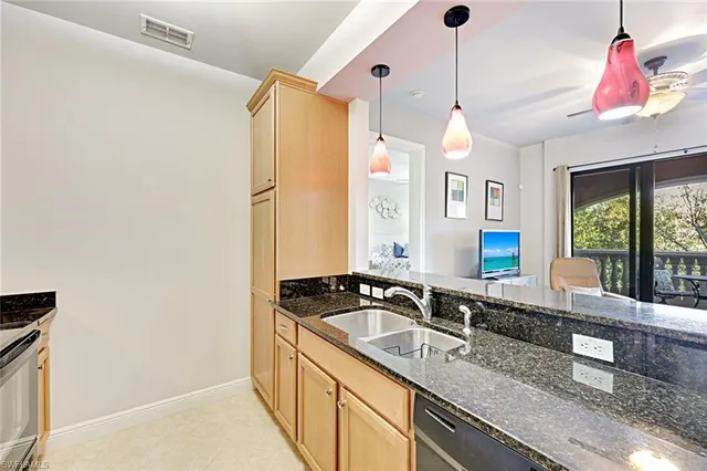 a kitchen with granite countertop a sink and a refrigerator