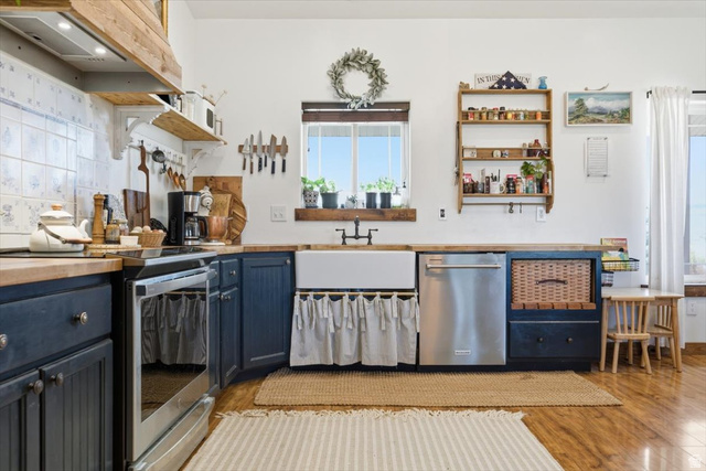 1634 West Arimo Road Arimo, ID 83214 - Photo 6 of 89 Kitchen featuring a farmhouse sink, stainless steel dishwasher, and wood-finish flooring