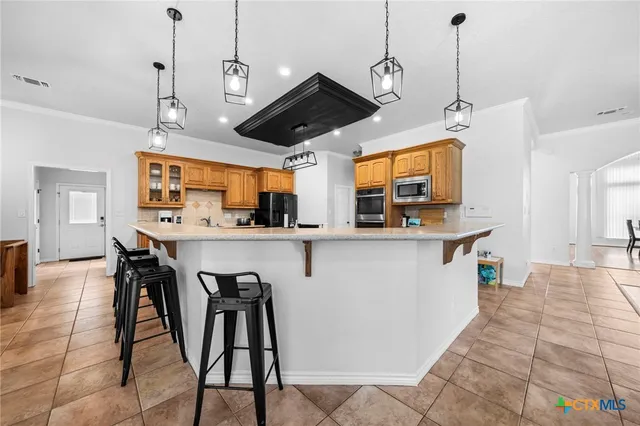 a kitchen with stainless steel appliances granite countertop a sink a stove and a refrigerator