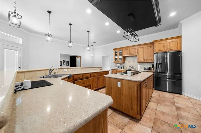 a kitchen with stainless steel appliances granite countertop a sink stove refrigerator and cabinets