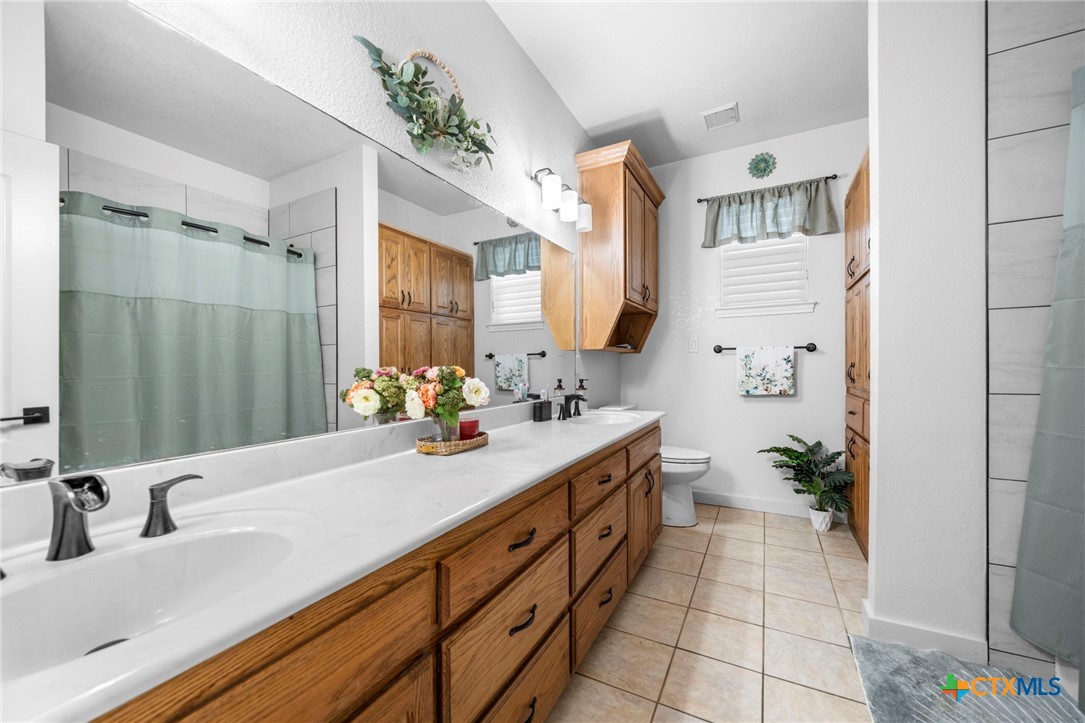 2383 Pecan Creek Road Killeen, TX 76549 - Photo 21 of 39 a bathroom with a double vanity sink a mirror and a shower