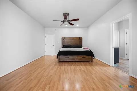 a bedroom with a bed and a ceiling fan