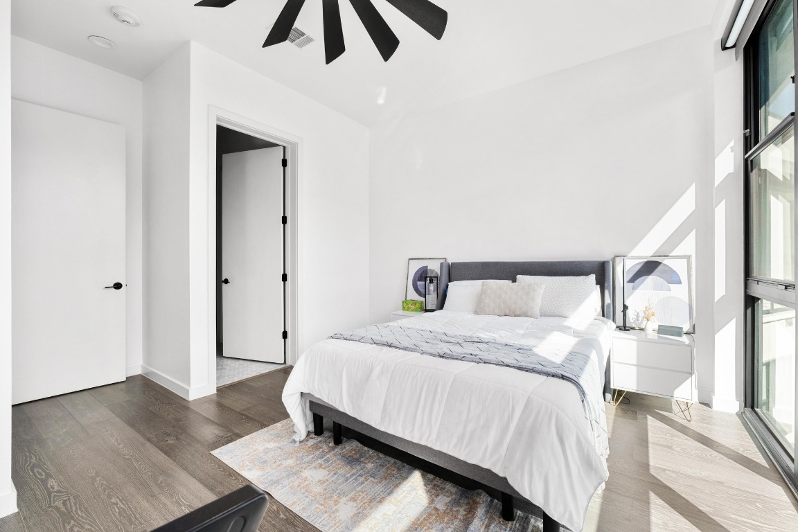 800 Embassy Drive, Unit 609 Austin, TX 78702 - Photo 9 of 33 a bedroom with a bed and wooden floor